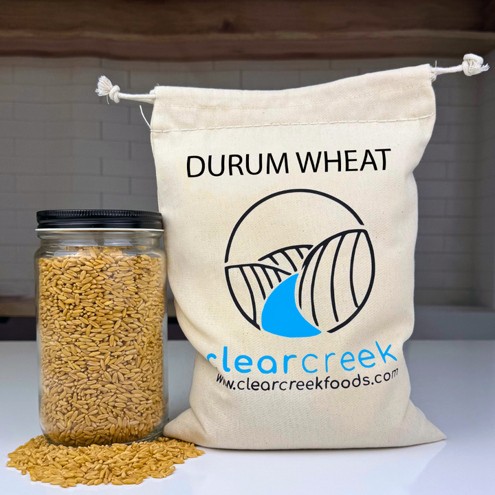 Bag labeled Durum Wheat next to a glass jar full of the same product.